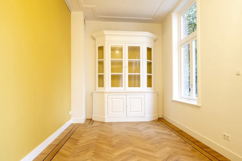 white cupbord in a yellow painted room